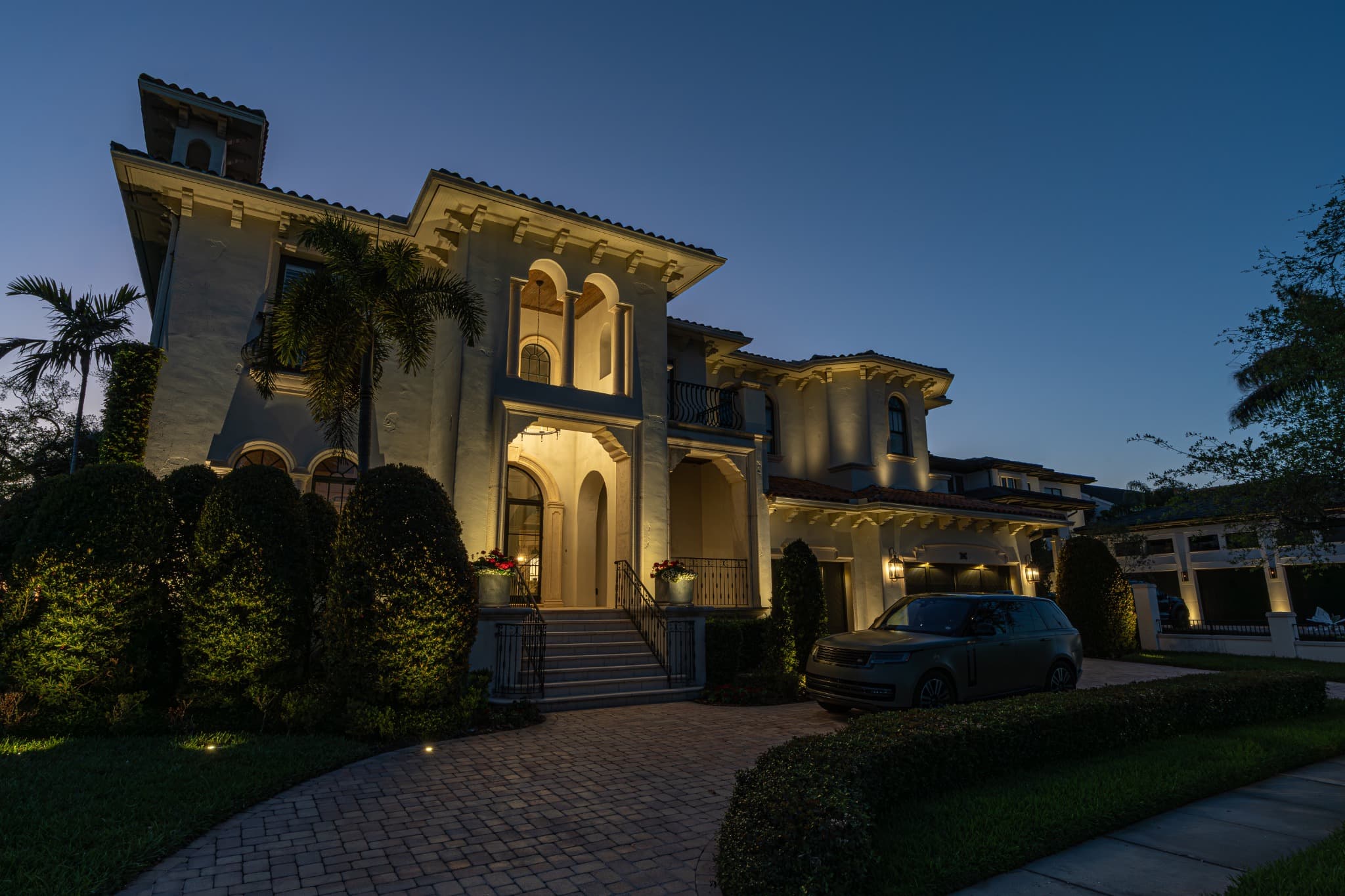 Tampa Bay estate with warm architectural and landscape lighting at dusk
